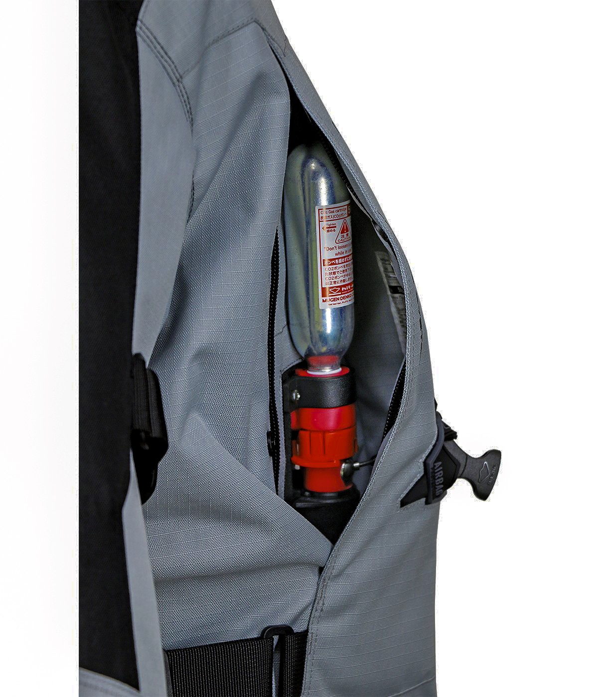 Caja de llave con cartucho de CO2 de 50cc, integrada de forma discreta bajo cremallera en el costado de la chaqueta.
